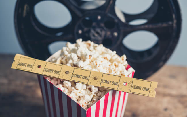 Old film reel, popcorn, cinema tickets