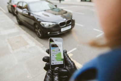 Woman waiting for uber car with app 400