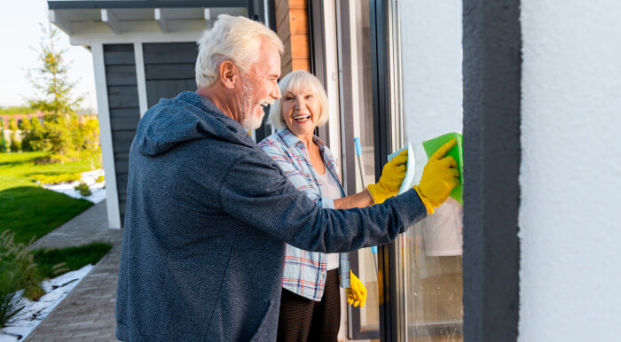 Elderly couple cleaning window